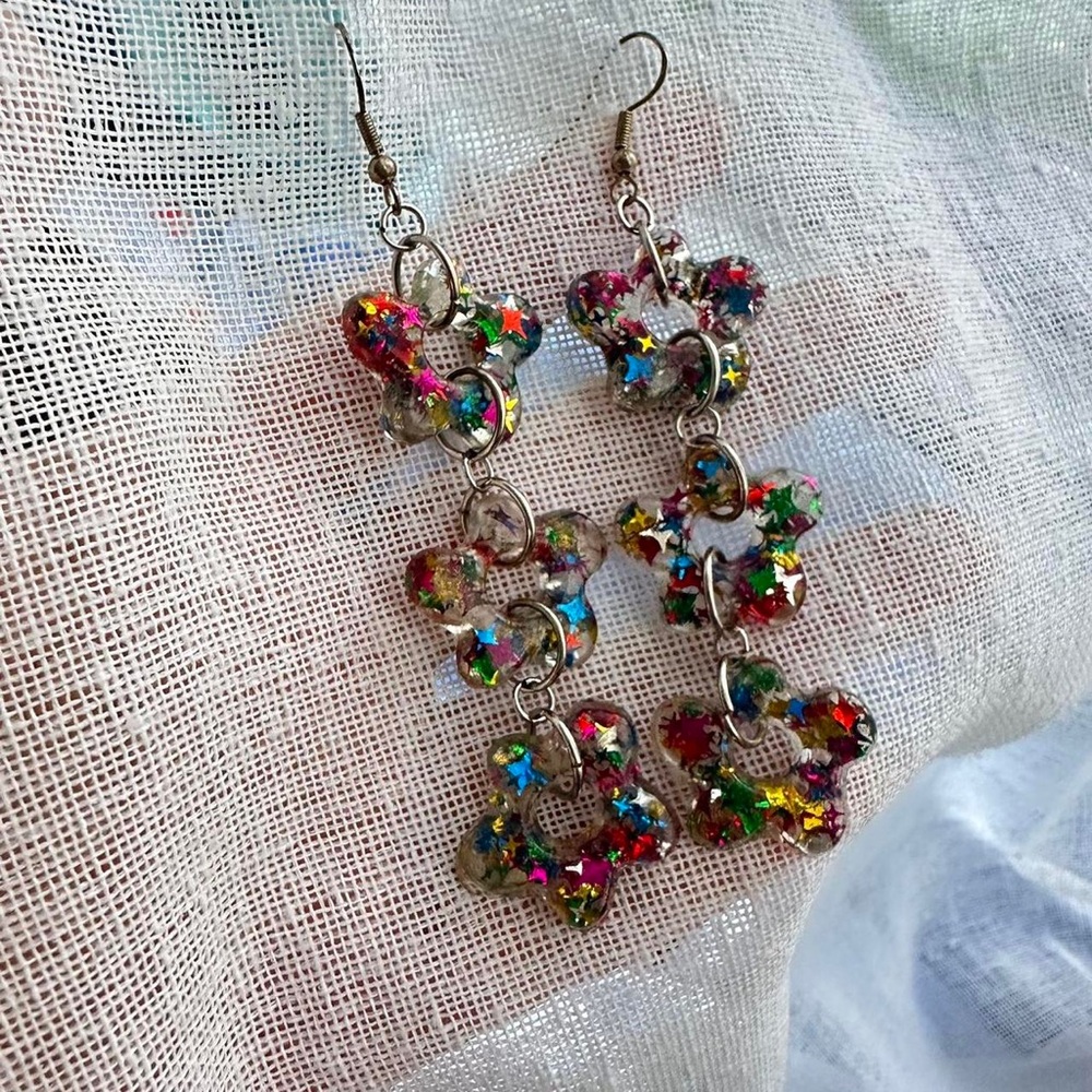 Joey Shares star confetti daisy flower resin dangle earrings.